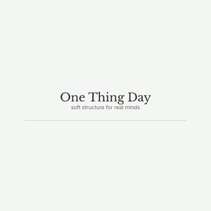 May include: A minimalist design featuring the text "One Thing Day" in a serif font, with the tagline "soft structure for real minds" below. The text is in a dark color against a light background.
