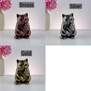 May include: Bronze, silver, and gold cat figurines, each with a hand gesture. The bronze cat has a dark brown finish, the silver cat has a metallic gray finish, and the gold cat has a shiny gold finish. The figurines are displayed with the text "Bronze", "Silver", and "Gold".