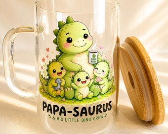 May include: A clear glass mug with a handle and a bamboo lid. The mug features a colorful illustration of a large green dinosaur holding a mug labeled DINO FUEL, surrounded by three smaller dinosaurs. The text PAPA-SAURUS & HIS LITTLE DINO CREW is printed below.