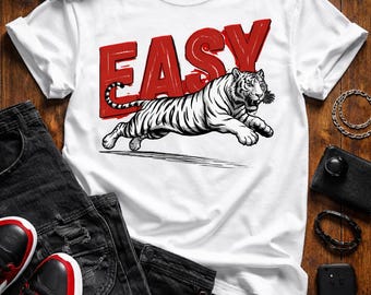 Camiseta gráfica de tigre fácil, divertida camiseta con cita motivacional, camiseta de tigre blanco saltando, top con tipografía roja llamativa, regalo unisex de ropa urbana.