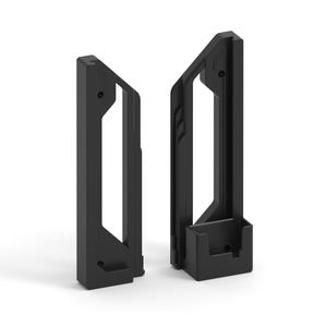 Puede incluir: Dos soportes negros de forma geométrica. Uno tiene una pequeña base rectangular, el otro una pequeña repisa. Ambos tienen un marco rectangular con un diseño recortado. Los soportes están diseñados para ser montados.