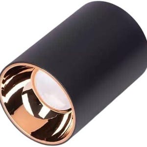 May include: A cylindrical black light fixture with a copper-colored interior and a white light source. The fixture is a simple, modern design, suitable for various interior styles.