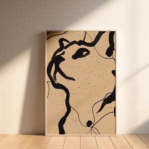 Puede incluir: Impresión artística abstracta con un diseño de tinta negra sobre fondo beige. La obra de arte, enmarcada en madera clara, muestra líneas y formas interconectadas, creando una estética minimalista. La pieza se exhibe contra una pared neutra.