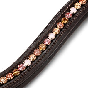 Puede incluir: Primer plano de una frontalera de brida de caballo de cuero marrón. La frontalera está adornada con una fila de cristales redondos y brillantes en tonos rosa, dorado y melocotón. Los cristales están engastados en cuero marrón oscuro.