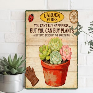May include: A rectangular metal sign with a wooden background features a red pot with succulents. The sign reads "GARDEN VIBES" and "YOU CAN'T BUY HAPPINESS... BUT YOU CAN BUY PLANTS (AND THAT'S BASICALLY THE SAME THING)". A ladybug and a wheel are also on the sign.