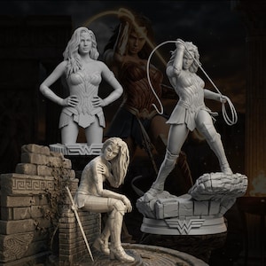 May include: A collection of Wonder Woman statues in various poses. The statues are in a light gray color, with intricate details of the character's costume and features. One statue is standing, holding a lasso, while another is seated. The background features a Wonder Woman image.