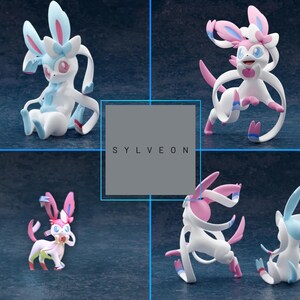 May include: Four figurines of Sylveon, a Pok&eacute;mon character, in various poses. The figures are primarily white with pink and blue accents. The text "SYLVEON" is displayed in a gray box in the center of the image.