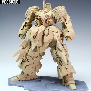 May include: A tan-colored Kshatriya model kit, a 1/100 scale statue, stands on a gray base. The model features intricate mechanical details, including segmented armor, multiple joints, and a detailed head with a prominent antenna. The text "NZ666-KSHATRIYA SPEC II" is visible.