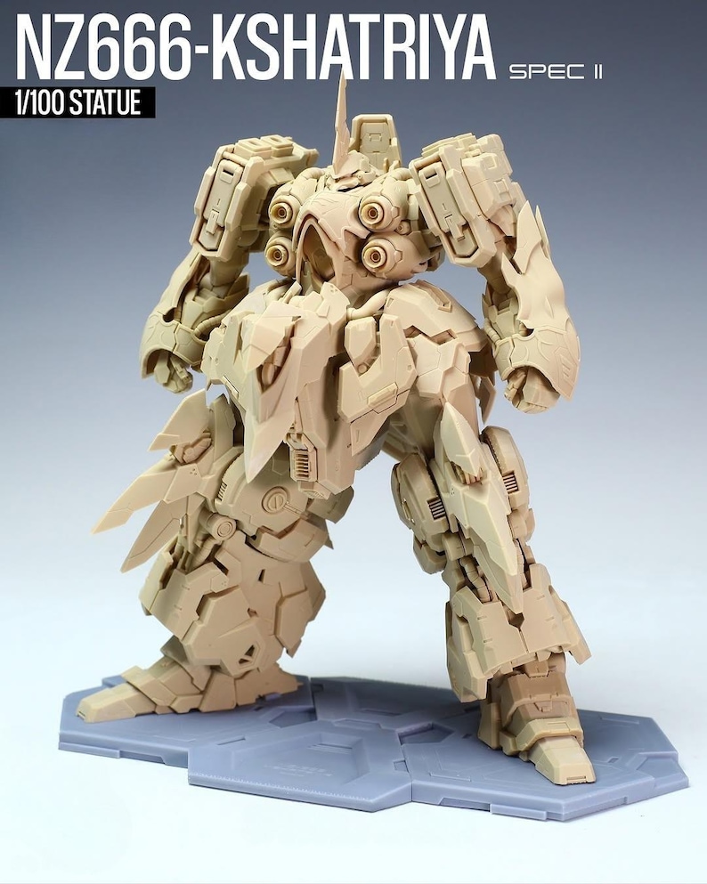 May include: A tan-colored Kshatriya model kit, a 1/100 scale statue, stands on a gray base. The model features intricate mechanical details, including segmented armor, multiple joints, and a detailed head with a prominent antenna. The text "NZ666-KSHATRIYA SPEC II" is visible.