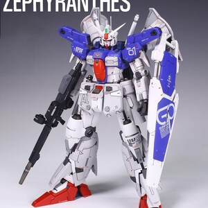 May include: A detailed model of a Zephyranthes robot, predominantly white with blue and red accents. The model features a large shield, a rifle, and the text "PROJECT 01 ZEPHYRANTHES" at the top. The robot has intricate mechanical details.