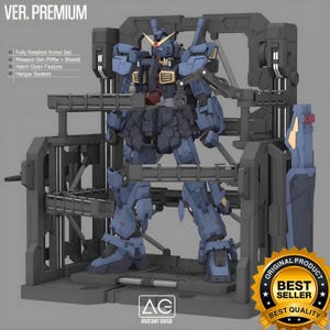 May include: A detailed blue and gray model kit of a mech robot, displayed within a gray hangar system. The model features a fully detailed armor set, weapon set (rifle and shield), and hatch open feature. The image includes the text "VER. PREMIUM" and "BEST SELLER".