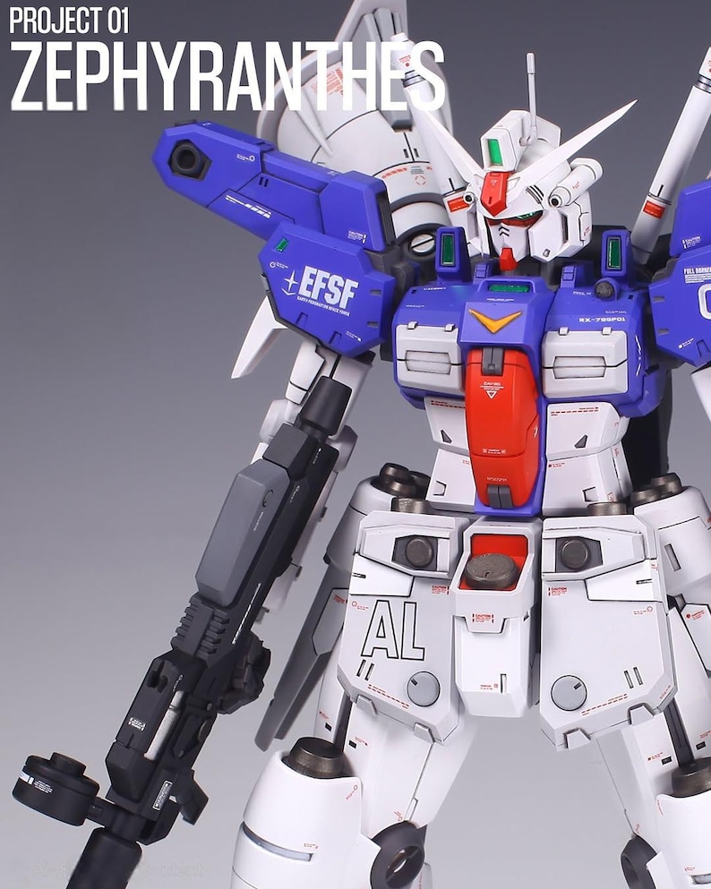 May include: A detailed model of a Zephyranthes robot, predominantly white with blue and red accents. The robot features intricate mechanical details, including a large gun and the text "EFSF" on its shoulder. The text "PROJECT 01 ZEPHYRANTHES" is at the top.
