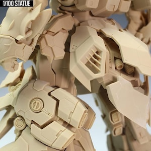 May include: A beige 1/100 scale statue of a detailed robot, featuring intricate paneling and mechanical components. The text "NZ666-KSHATRIYA SPEC II" is visible at the top, with "1/100 STATUE" below.