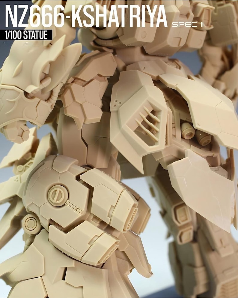 May include: A beige 1/100 scale statue of a detailed robot, featuring intricate paneling and mechanical components. The text "NZ666-KSHATRIYA SPEC II" is visible at the top, with "1/100 STATUE" below.