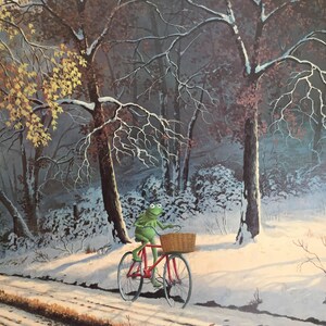 May include: A whimsical illustration of a green frog riding a red bicycle with a basket through a snowy forest. The trees are bare, and the ground is covered in snow, suggesting a winter scene.