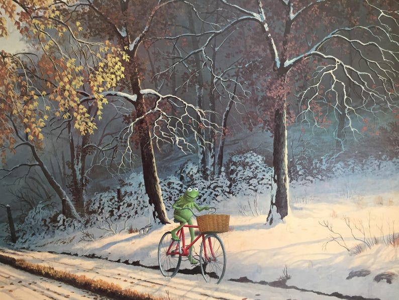 May include: A whimsical illustration of a green frog riding a red bicycle with a basket through a snowy forest. The trees are bare, and the ground is covered in snow, suggesting a winter scene.