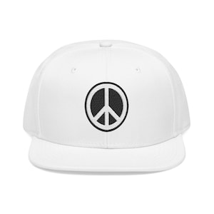 May include: A white snapback cap featuring a circular black and white embroidered peace sign emblem centered on the front panel. The hat has a structured crown, a flat brim, and a button on the top, showcasing a clean and simple design.