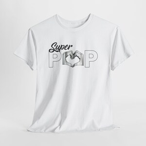 May include: White t-shirt with the text "Super Pop" in a black script font. The word "Pop" features a heart-shaped design in the center. The shirt is made of a soft material and has short sleeves.