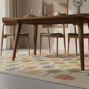 K&ouml;nnte beinhalten: Ein Esstisch aus Holz mit vier St&uuml;hlen, gedeckt mit Tellern, Gl&auml;sern und Kerzen. Der Tisch steht auf einem gemusterten Teppich mit bunten geometrischen Formen. Der Raum hat eine neutrale Farbpalette mit nat&uuml;rlichem Licht.