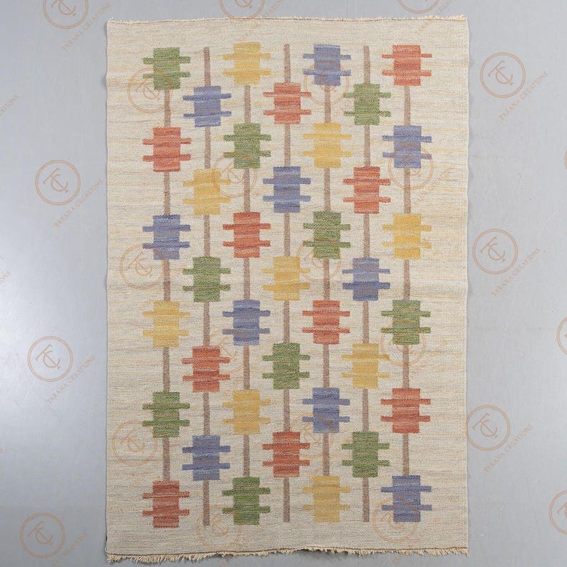 Full view of handwoven Scandinavian wool area rug with cream base and colorful geometric motifs.
Nordic flat weave rug featuring mustard yellow, dusty blue, olive green, and rust red shapes.
Modern geometric wool carpet with vertical brown stripe structure and balanced layout.
Handmade cream area rug for living room, bedroom, or farmhouse decor.
Contemporary Nordic wool rug with symmetrical patterned design and flat weave texture.