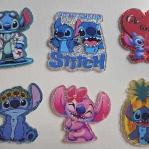 May include: A collection of glittery, cartoon character pins featuring Stitch and Angel. Designs include Stitch as a doctor, Stitch with Angel, Stitch with a sunflower crown, and Stitch in a pineapple.