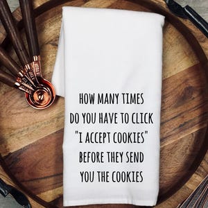 May include: White kitchen towel with black text that reads "How many times do you have to click "I accept cookies" before they send you the cookies."