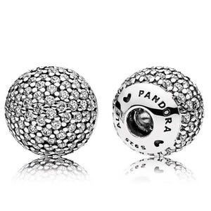 May include: Two silver Pandora charm beads. Each bead is spherical and covered in small, clear crystals. One bead has the word "PANDORA" and "ALE" engraved on it. The beads are reflected on a white surface.