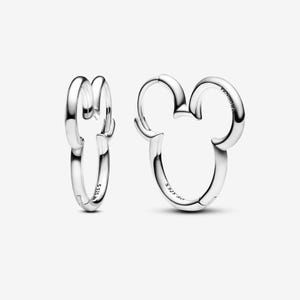 Peut inclure: Une paire de boucles d'oreilles créoles argentées. Une boucle d'oreille est en forme de tête de Mickey Mouse, avec deux cerceaux arrondis pour les oreilles. L'autre boucle d'oreille est une créole simple. Les deux ont une surface brillante et réfléchissante.