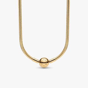 Könnte beinhalten: Eine goldfarbene Halskette mit Schlangenketten-Design. Die Halskette hat einen runden Verschluss mit dem eingravierten Wort "PANDORA". Die Kette besteht aus kleinen, ineinandergreifenden Gliedern, die eine glatte, flexible Textur erzeugen.