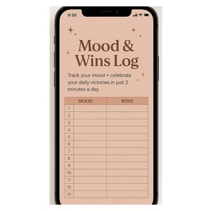 May include: A smartphone displays a digital mood and wins log. The screen features the text "Mood & Wins Log" with instructions to track mood and celebrate daily victories. A table is visible with columns for mood and wins, and numbered rows.