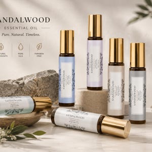 Può includere: Sei flaconi in vetro con applicatore a sfera di olio essenziale di sandalo con tappi dorati. Le etichette riportano il testo Sandalwood Essential Oil, Pure, Natural, Timeless e icone per ingredienti naturali, oli puri e senza parabeni. I flaconi sono disposti su superfici in pietra.