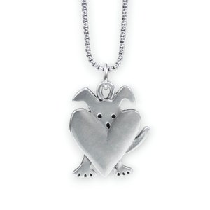May include: Silver necklace with a charm of a dog holding a heart in its paws.