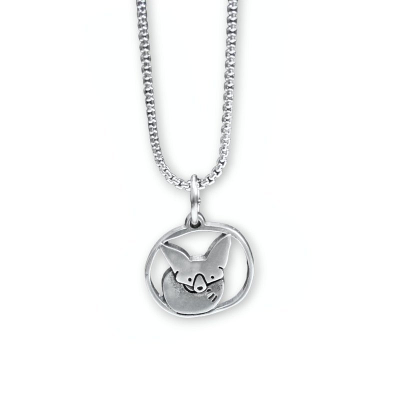 May include: A silver necklace with a pendant featuring a stylized fox curled up inside a circle.