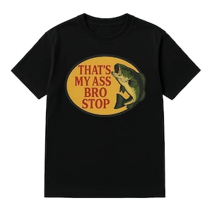 K&ouml;nnte beinhalten: Schwarzes T-Shirt mit einem ovalen Aufdruck, der einen gr&uuml;nen Fisch und den Text "THAT'S MY ASS BRO STOP" in Wei&szlig; und Rot zeigt. Das Shirt hat einen Rundhalsausschnitt.