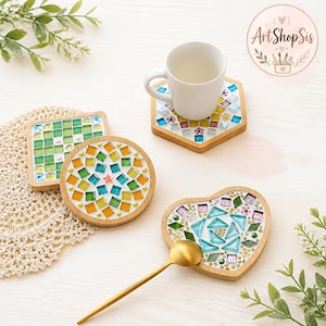 Pu&ograve; includere: Un set di quattro sottobicchieri in legno con design a mosaico di forma quadrata, esagonale, circolare e a cuore. Le tessere sono nei toni del verde, blu, giallo e viola, arricchite da piccole perline. Sono inclusi una tazza bianca e un cucchiaio dorato.