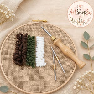 May include: A wooden embroidery hoop containing tan fabric with three vertical rows of yarn in dark brown, forest green, and white. A punch needle tool with a wooden handle and two additional metal needle tips are placed on the fabric.