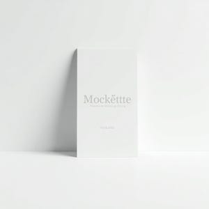 Op de afbeelding: Een verticale rechthoekige witte kaart met de lichtgrijze tekst Mockette Premium Mockup Store en PSD&JPEG in het midden gedrukt. De kaart staat rechtop tegen een effen witte achtergrond en toont een strak en eenvoudig ontwerp.