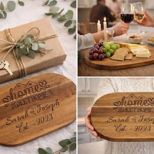 May include: A wooden serving board with the text "home sweet home" and the names "Sarah & Joseph Est. 2023" is displayed. A gift box tied with twine and a key charm is also shown.