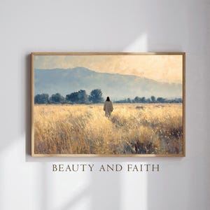 May include: Framed art print featuring a figure walking through a golden field towards a mountain range. The artwork has a warm color palette with the text "BEAUTY AND FAITH" at the bottom. The print is in a wooden frame.