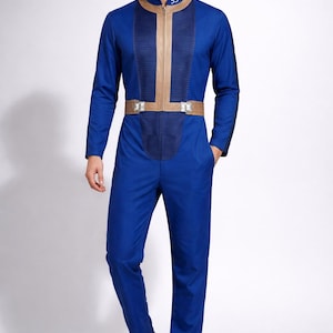 Puede incluir: Mono azul con cuello, rayas verticales y cinturón beiges. El mono tiene una cremallera en la parte delantera y el número 33 en el cuello. La persona lleva zapatos blancos.