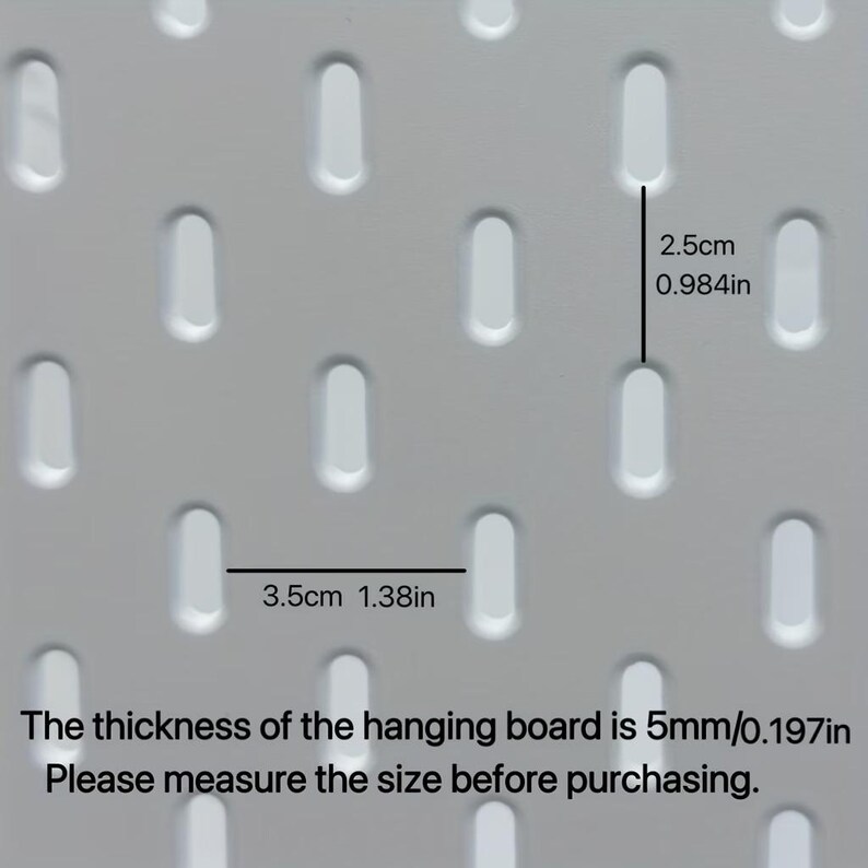 Op de afbeelding: Een wit pegboard met een herhalend patroon van verticale ovale sleuven. De verticale afstand tussen de sleuven is 2,5 cm en de horizontale afstand is 3,5 cm. De dikte van het bord is 5 mm. Tekst: The thickness of the hanging board is 5mm/0.197in. Please measure the size before purchasing.