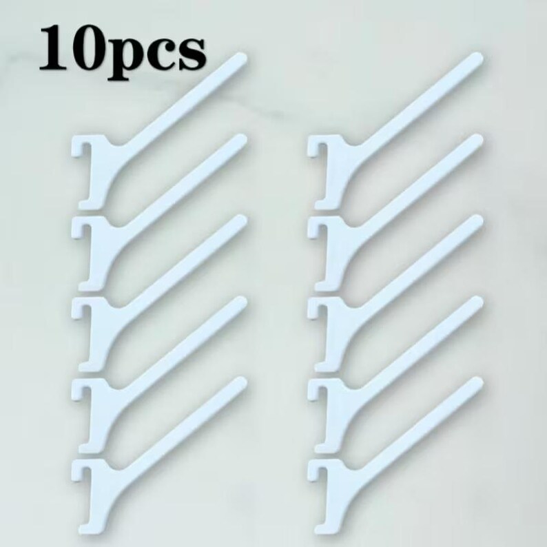 Op de afbeelding: Een set van 10 witte plastic displayhaken gerangschikt in twee verticale kolommen van vijf. Elke haak heeft een platte, schuine arm die uitsteekt vanaf een inkeping-montagebasis voor bevestiging aan een wanddisplay.