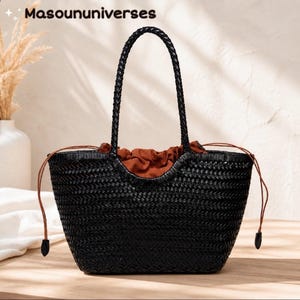 Puede incluir: Bolso tote tejido negro con asa trenzada y cierre de cordón. El bolso tiene un interior marrón y cordones marrones. El texto "Masoununiverses" está en la esquina superior izquierda.