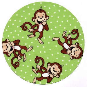 May include: Four brown monkeys with white faces and white teeth are laughing. They are on a green background with white polka dots.