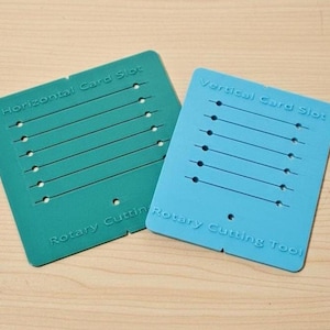 May include: A dark green rectangular template labeled Horizontal Card Slot and Rotary Cutting Tool, and a light blue rectangular template labeled Vertical Card Slot and Rotary Cutting Tool, both featuring multiple parallel slots for cutting.