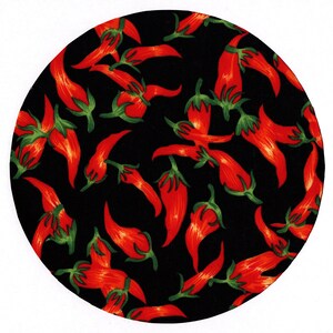 May include: A circular design featuring a pattern of red chili peppers with green stems scattered across a black background. The peppers are detailed with shading, giving them a realistic appearance. The overall design is bold and eye-catching.