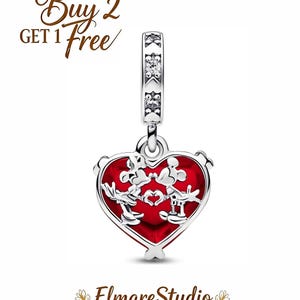 Puede incluir: Un charm de plata con un colgante rojo en forma de coraz&oacute;n con Mickey y Minnie Mouse. El charm tiene una fianza decorativa y el texto "Buy 2 Get 1 Free". El logotipo "ElmareStudio" est&aacute; en la parte inferior.