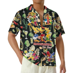 May include: Black short-sleeved button-down shirt with a colorful cartoon design. The pattern includes cartoon characters, tequila bottles, limes, and the text "Margaritas Por Favor". The shirt is open at the collar.
