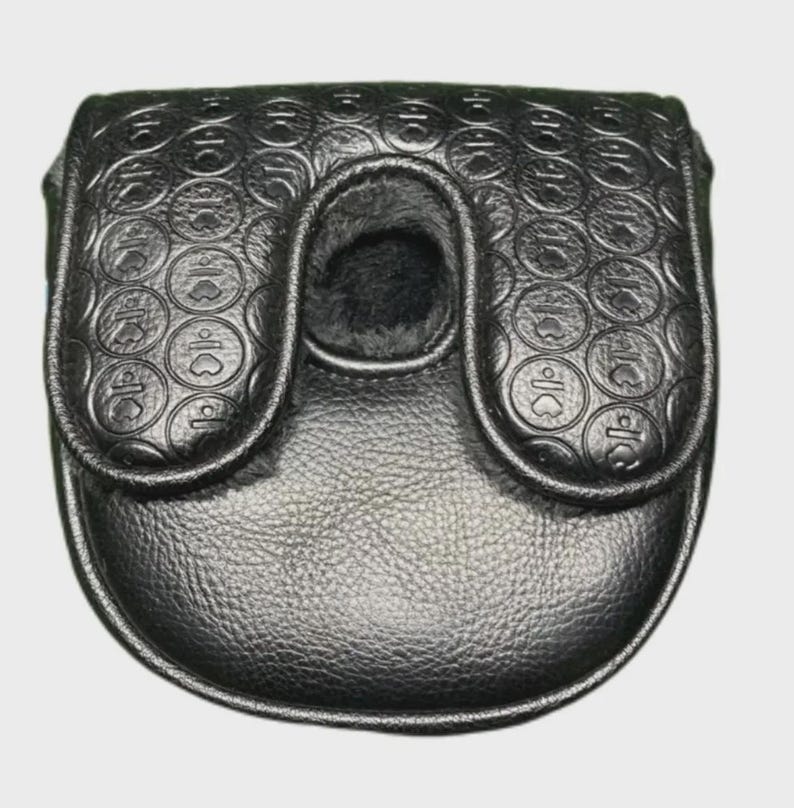 以下が含まれることがあります： 黒い革製のゴルフパターカバー。 フラップ開閉式で、クラブのシンボルを含む円の繰り返し模様がエンボス加工されています。 内側は柔らかく暗い素材で裏打ちされています。
