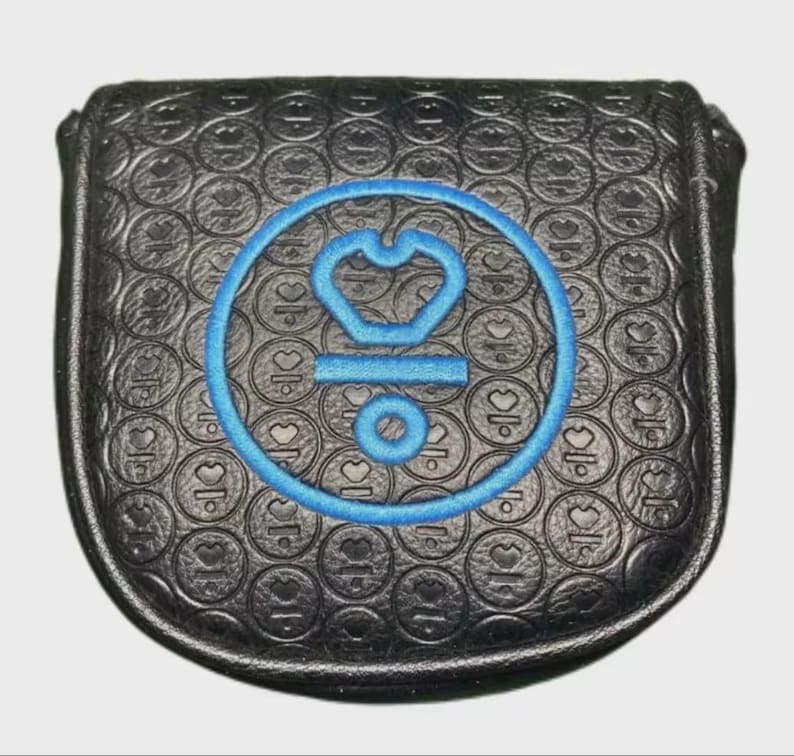 以下が含まれることがあります： 青い刺繍デザインの黒いゴルフパターカバー。カバーには円とハートのテクスチャパターンがあります。青いデザインは王冠、水平線、円が特徴です。カバーは耐久性のある素材で作られています。